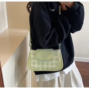 Détail du sac sous le bras à carreaux vert clair avec bordure en similicuir et boucle
