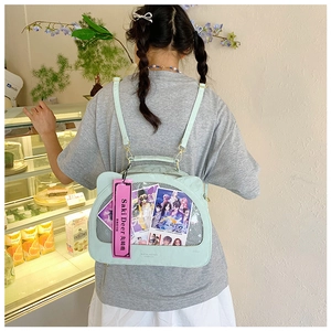 Detail of mint green cat ear ita bag with a large transparent window and gold hardware