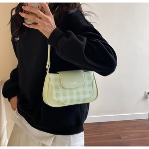 Détail du sac sous l'aisselle à carreaux vert clair avec logo et bandoulière réglable