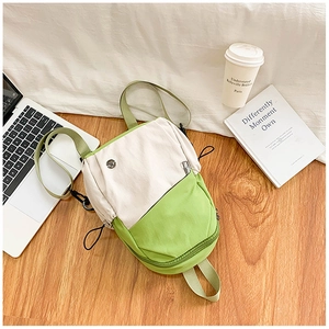 Détail du sac à dos étanche en toile crème et vert avec design de blocs de couleurs