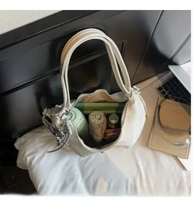 Vue de dessus d'un sac hobo blanc montrant un intérieur spacieux avec des objets du quotidien