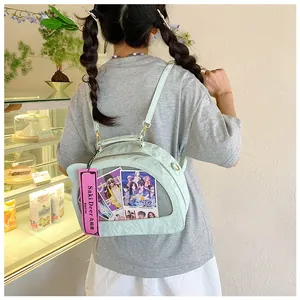 Detail of mint green itabag with transparent PVC window shown on a model in a cafe