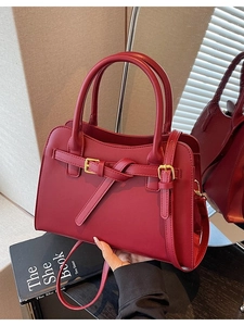 Deep red tote bag with gold buckle hardware and adjustable strap for wedding use