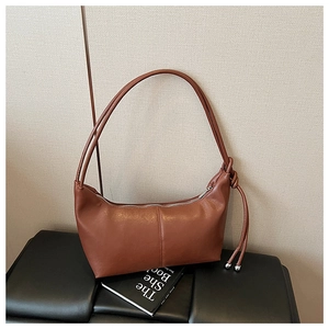 Detail view of the vintage tan leather crescent bag with silver metallic zip closure