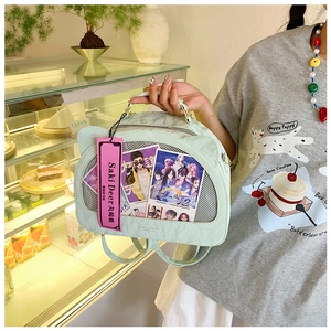 Detail of mint green ita bag with clear window and mesh panel in a cozy cafe setting