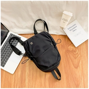 Détail du sac à dos en nylon noir imperméable sur parquet avec café et ordinateur