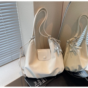 Détail d'un sac cabas en cuir PU blanc cassé avec pendentif étoile argenté et texture souple