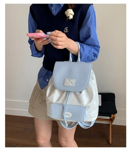 Vue détaillée du sac à dos en toile bleu et blanc avec motifs de chats et cordon