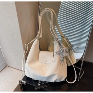 Détail d'un sac demi-lune blanc crème avec finition brillante et breloque étoile argentée