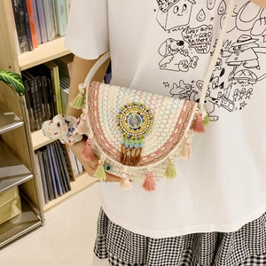 Detail of bohemian woven bucket bag with colorful geometric embroidery and fringe tassels