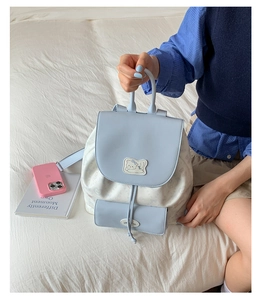 Détail du sac à dos bleu clair avec imprimé chat et rabat en similicuir à cordon