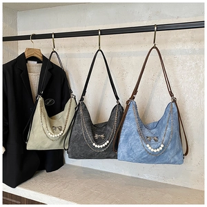 Three stylish tote bags in green, grey, and blue with bow and chain accents