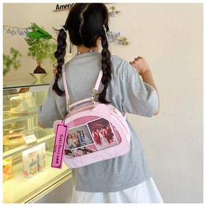 Detailed view of pink Ita bag with transparent window for display and adjustable strap