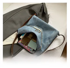 Internal view of a large capacity blue denim tote bag with brown straps and pearls