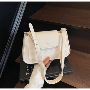 Détail du sac à bandoulière en cuir PU crème avec texture gaufrée et logo mode