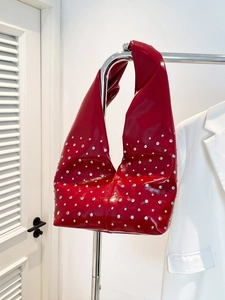 Red glossy patent leather hobo bag with silver rivets and crescent moon shape