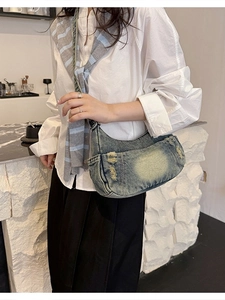 Vintage denim crescent crossbody bag with washed distressed finish and frayed details