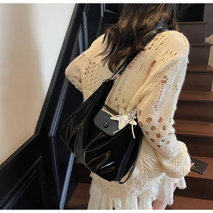 Détail du sac cabas noir brillant avec pendentif étoile argenté et plis latéraux
