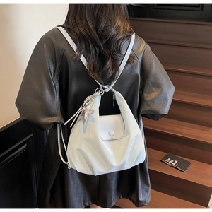 Détail du sac à dos bleu clair en forme de nuage avec finition brillante et breloque étoile