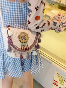 Bohemian off-white woven crossbody bag with colorful tassels and beaded mandala detail