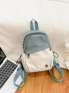 Sac à dos multifonctionnel imperméable en toile bleu et beige sur un bureau en bois