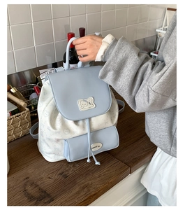 Détail du sac à dos bleu clair avec imprimé ours et écusson de chat mignon