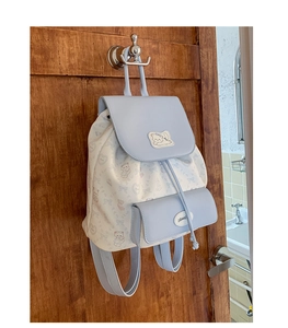 Vue détaillée du sac à dos bleu et beige avec motifs d'animaux et fermeture par cordon serrage