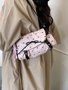 Pink pleated shoulder bag with black bow embroidery and decorative pearl ribbon pendant