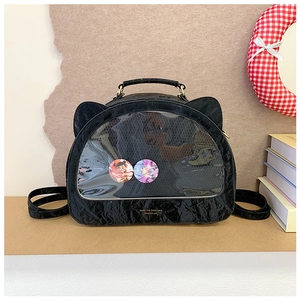 Detail of black cat-ear ita-bag featuring a transparent PVC window and gold typography