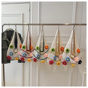 Détail de cinq sacs à bandoulière en crochet aux fleurs colorées suspendus en rayon