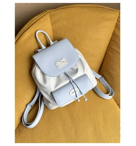Détail du rabat en cuir PU bleu et du patch chat sur le sac à dos en toile