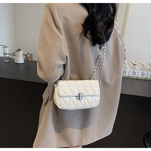 Model view showing the scale of a white quilted chain bag with silver clasp detail