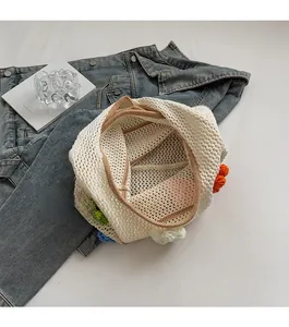 Détail d'un sac cabas au crochet avec fleurs tricotées colorées et bordure marron élégante