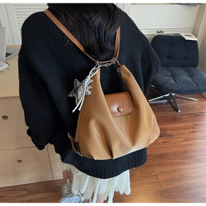 Sac fourre-tout vintage caramel porté en sac à dos avec breloque étoile en argent