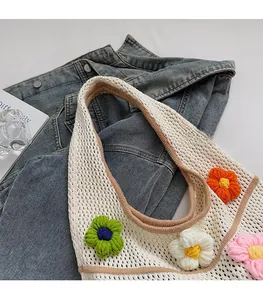 Détail du sac cabas ajouré crocheté main avec fleurs tricotées colorées et bandoulière large