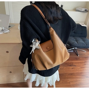 Détail du sac hobo rétro camel avec pendentif étoile, rabat aimanté et cuir PU lisse