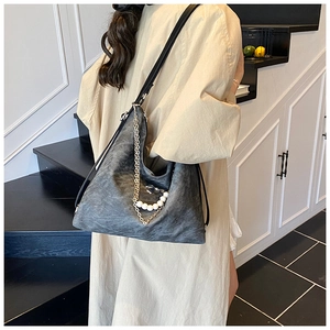 Detail of charcoal grey tote bag with pearl and metal chain accents on shoulder strap