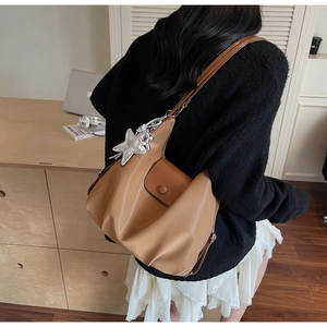 Détail du sac cabas vintage en cuir PU marron avec breloque étoile et design plissé