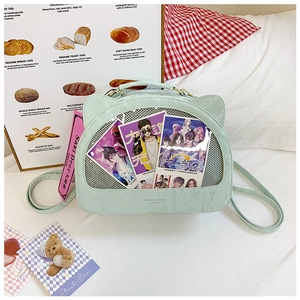 Detail view of mint green cat-ear ita bag with transparent window and cartoon insert