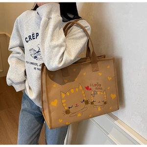 Grand sac cabas en toile marron avec imprimé chat porté par un mannequin de profil