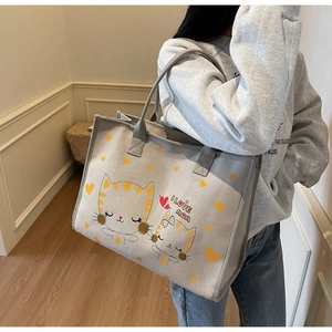 Vue détaillée du grand sac cabas en toile avec imprimé chat porté à l'épaule du mannequin