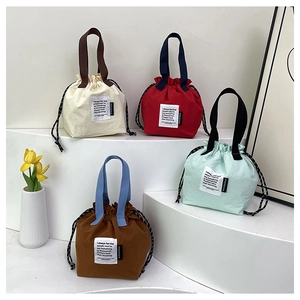 Minimalist drawstring lunch bags in multiple colors shown in a tiered display