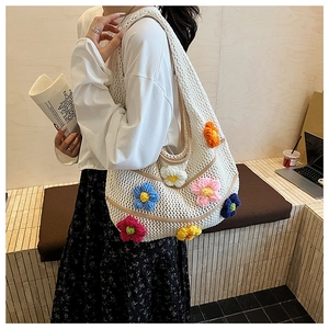 Détail du sac cabas en tricot blanc avec fleurs au crochet 3D et texture ajourée