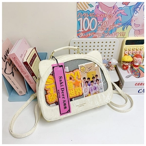 Detailed view of white cat-eared ita bag with transparent window and colorful accessories