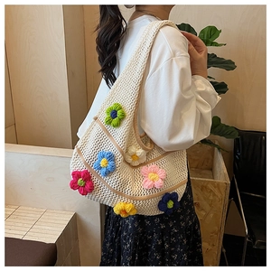 Gros plan du sac fourre-tout en crochet blanc avec ornements floraux 3D colorés