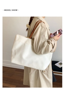 Model wearing white canvas tote bag with brown leather handles for casual commute
