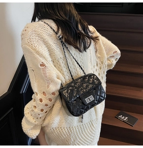 Vue arrière d'un mannequin portant un sac matelassé noir à chaîne sur un escalier
