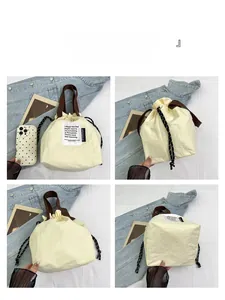 Detail view of cream insulated lunch bag with drawstring closure and brown handles