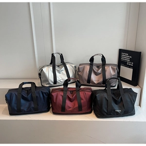 Close-up of waterproof nylon travel bags in five colors on a minimalist white stand
