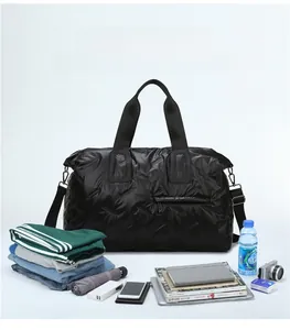 Large black quilted travel bag showing spacious interior with clothes and accessories